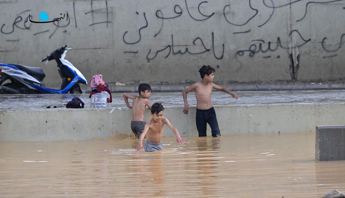 صوراً لعدد من الفتيان الذين يبيعون المناديل الورقية في الشوارع وهم يسبحون في سيول نهر بيروت